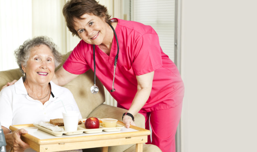 caregiver serving breakfast to an old woman