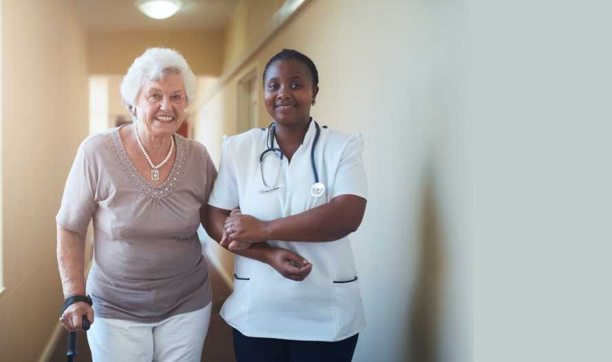 caregiver assisting an old woman in the hallway